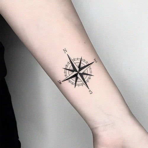Black compass rose temporary tattoo on forearm, stylish waterproof design for expressive body art.