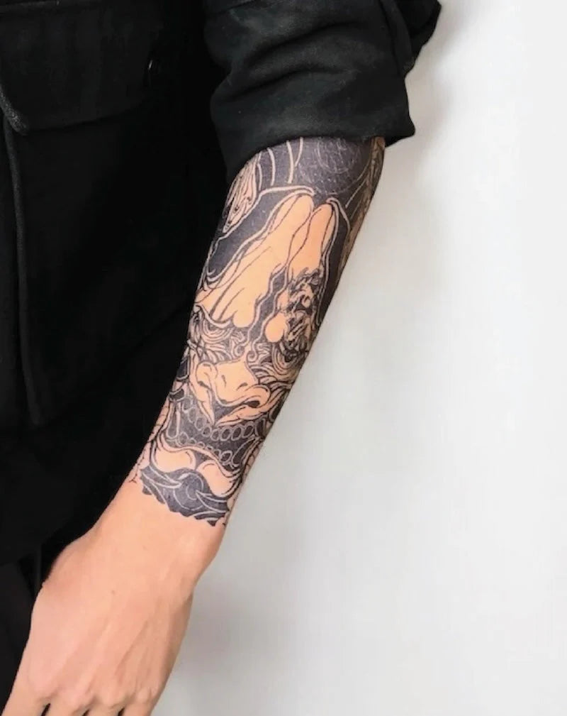 Tattoo sleeve with dragon design on a person's arm against a white background