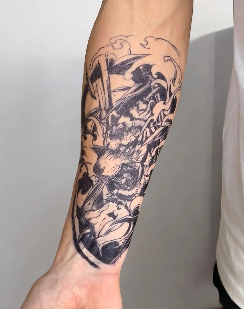 Detailed black Stattoo on a person's arm against a neutral background